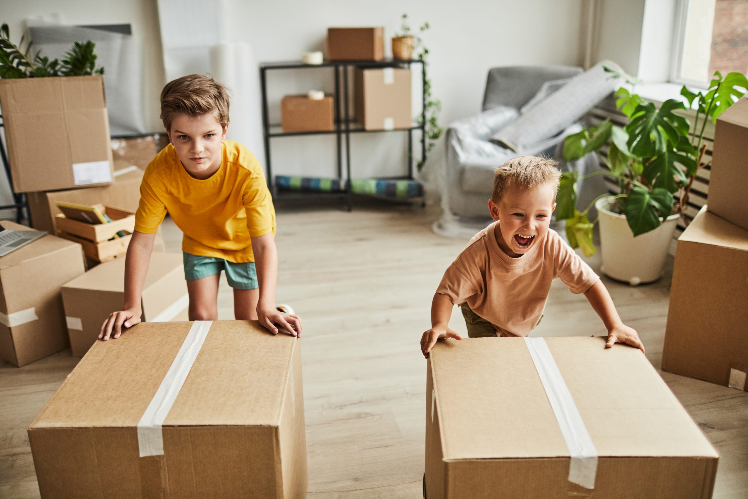 des enfants qui joue avec des cartons de déménagement